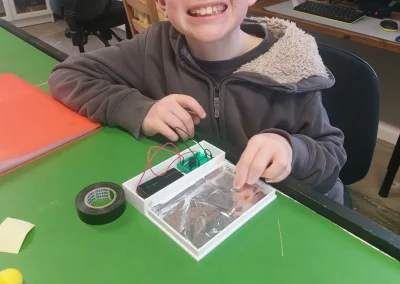 Student building electronics in 3d printed case