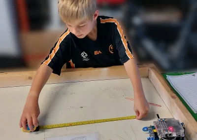 Student measuring mbot travel distance
